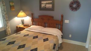a bedroom with a bed and a lamp on a table at 2 bedroom Wiffen Cottage in Port Albert
