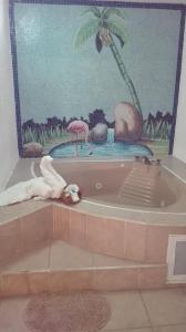 baño con bañera con una pintura en la pared en Hotel Ollin Teotl, en San Juan Teotihuacán