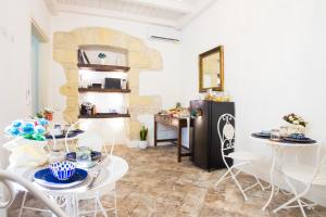 Una cocina con mesa y sillas y un refrigerador. en La Residenza Sul Largo, en Cagliari