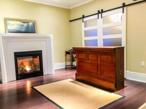 a living room with a fireplace and a wooden altar at Newsroom Suites in Wellington