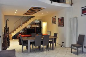 a dining room with a table and chairs and a staircase at Suite Monticelli in Naples +39 photos