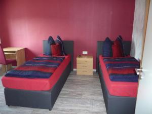 twee bedden in een kamer met rood en blauw bij Harzurlaub in Blankenburg