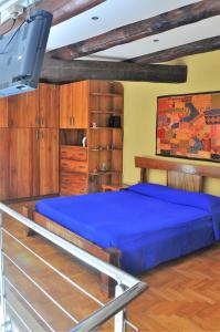 a bedroom with a blue bed and a tv at Suite Monticelli in Naples