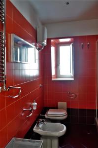 een rode badkamer met een toilet en een wastafel bij Suite Monticelli in Napels