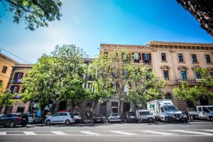 Una calle de la ciudad con coches aparcados delante de un edificio. en La Residenza Sul Largo, en Cagliari