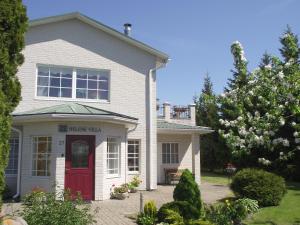 Biały ceglany dom z czerwonymi drzwiami w obiekcie Helene Villa w mieście Kuressaare