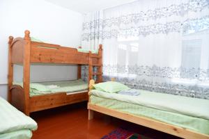a bedroom with two bunk beds and a window at Sonun Hostel in Karakol
