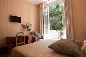 a bedroom with a bed and a large window at Hotel Villa Delle Rose in Rome