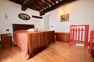1 dormitorio con 1 cama en una habitación con suelo de madera en Luciano e Norma House Il Rustico, en Gerfalco