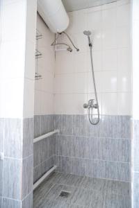 a bathroom with a shower with gray and white tiles at Sonun Hostel in Karakol +18 photos