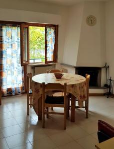 cocina con mesa, sillas y chimenea en Casa Vacanze Sia, en Caramanico Terme