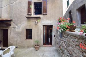 una entrada a un edificio con flores y una puerta en Luciano e Norma House Il Rustico, en Gerfalco