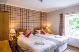 two beds in a small room with a window at Elan Hotel in Rhayader