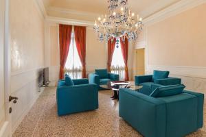 a living room with blue chairs and a chandelier at Villa Volpi in Mogliano Veneto