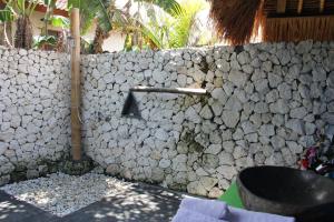 una pared de piedra con una letra a en ella en The Calmtree Bungalows, en Canggu