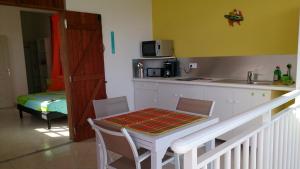 a kitchen with a table and a counter with a table and chairs at Côté Caraïbes in Bouillante
