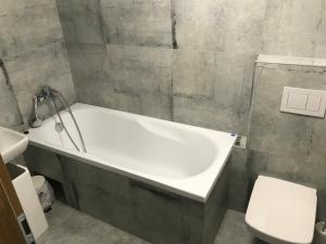 a bathroom with a bath tub and a toilet at Willa Plaza in Łeba +55 photos