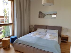 ein Schlafzimmer mit einem Bett mit zwei Handtüchern darauf in der Unterkunft JPapartments Nadmorski Dwór in Danzig