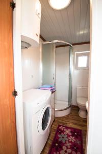 a small bathroom with a washing machine and a toilet at Kingsajz in Giżycko