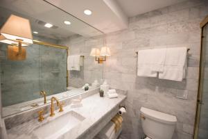 a bathroom with a sink and a toilet and a mirror at Yachtsman Lodge & Marina in Kennebunkport