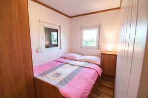 a small bedroom with a bed and a window at Kingsajz in Giżycko