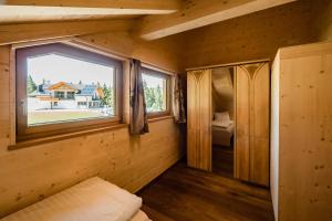 mały pokój z oknem w drewnianym domku w obiekcie Camping Chalet Salten w mieście Jenesien