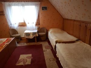 Habitación pequeña con 2 camas y ventana en Olsik en Białowieża