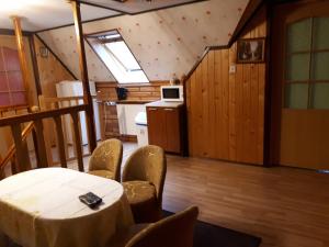 a room with a table and chairs and a kitchen at Olsik in Białowieża
