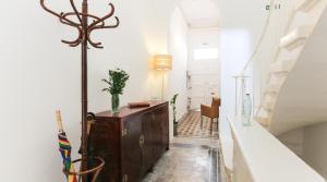 een hal met een houten dressoir en een trap bij House of Pomegranates in Sliema