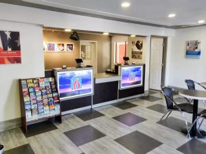 a waiting room with two televisions and a table at Studio 6-Fresno, CA - Extended Stay in Pinedale