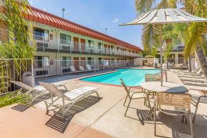 a patio with a table and chairs and a swimming pool at Studio 6-Fresno, CA - Extended Stay in Pinedale