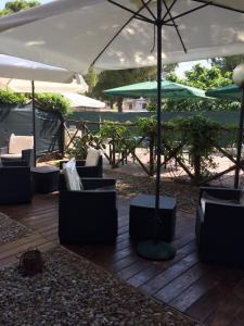 a patio with chairs and an umbrella on a deck at Appartahotelpuglia Gruppo Albergo Lamanna in Taranto