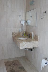 a bathroom with a sink and a mirror at Solar do Centro in Gramado