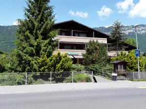 un edificio junto a una carretera con una valla en Hotel Walida en Bönigen