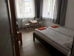 1 dormitorio con 2 camas, mesa y sillas en Marynarska 19, en Darłówko