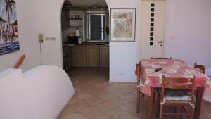 a dining room with a table and chairs and a kitchen at CASA CENTRO STORICO RIMINI in Rimini