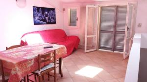 a living room with a red couch and a table at CASA CENTRO STORICO RIMINI in Rimini