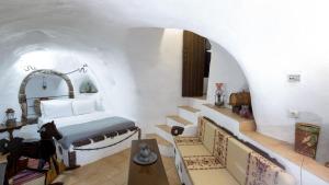 a bedroom with a bed and stairs in a room at Mylopetres Traditional Houses Finikia in Oia