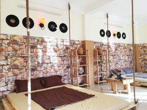 a bedroom with a stone wall and a hanging bed at BAP.Homestay in Ho Chi Minh City