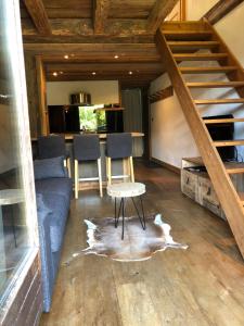 sala de estar con escalera, mesa y sillas en Appartement du Petit Bois en Megève