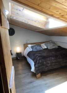 a bed in a room with a wooden ceiling at Appartement du Petit Bois in Megève