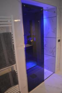 un ascenseur en verre avec des lumières bleues dans une pièce dans l'établissement B&B Vesuvius, à Naples