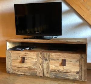 a tv sitting on top of a wooden entertainment center at Appartement du Petit Bois in Megève