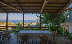 una mesa y sillas en un patio con vistas al océano en Pension Andromeda, en Patitiri