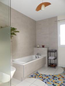 a white bathroom with a tub and a sink at Les Enselmes in Montagnieu