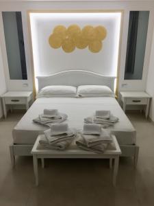 Una cama blanca con toallas encima. en B&B Bella Costa - lungomare Porto Cesareo, en Porto Cesareo