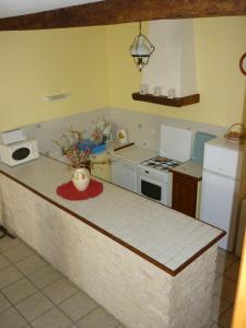 a kitchen with a counter top and a stove top oven at Gîte Le Logis de Faugerit in Frontenay-Rohan-Rohan