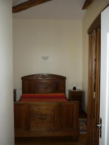 1 dormitorio con cama de madera en una habitación en Gîte Le Logis de Faugerit, en Frontenay-Rohan-Rohan