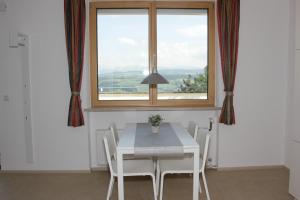 a dining room with a table and a window at Schönblick Hotel Garni Ferienwohnungen in Lindenberg im Allgäu