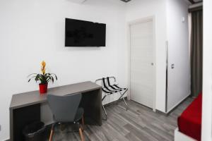 Colomba Welcome في تراباني: غرفة بها مكتب وتلفزيون على الحائط